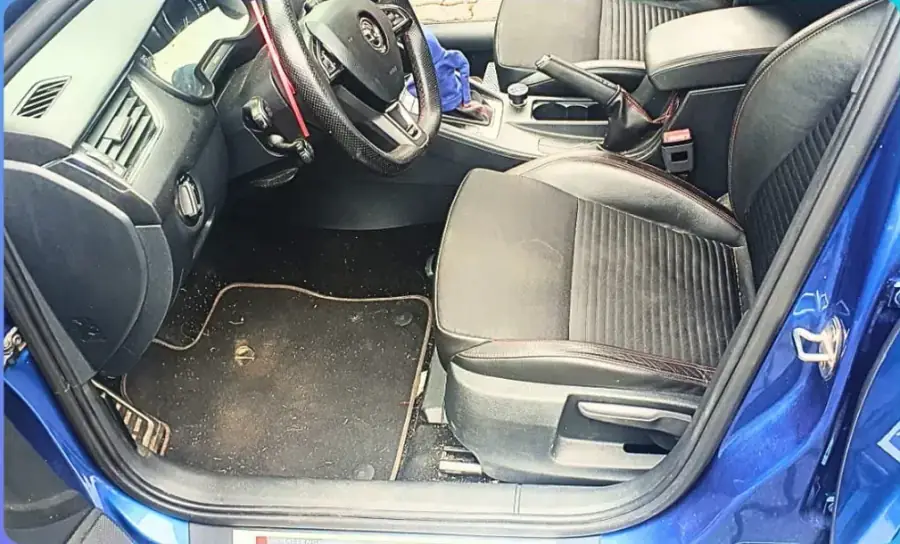 Fahrerseite vorher, mit verschmutzter Fußmatte und Schmutz im Fußraum